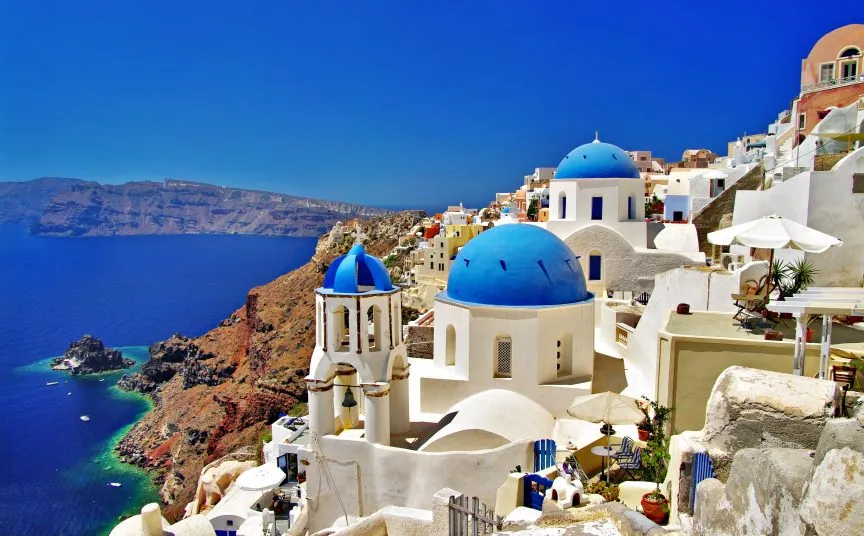 Iconic white buildings and blue domes of Santorini, Greece overlooking the Aegean Sea